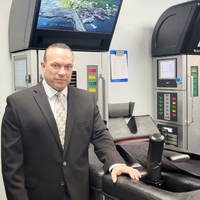 Picture of a Dr. Durlan Castro standing in front of the DRX9000 machine for herniated disc treatment in Commack, NY